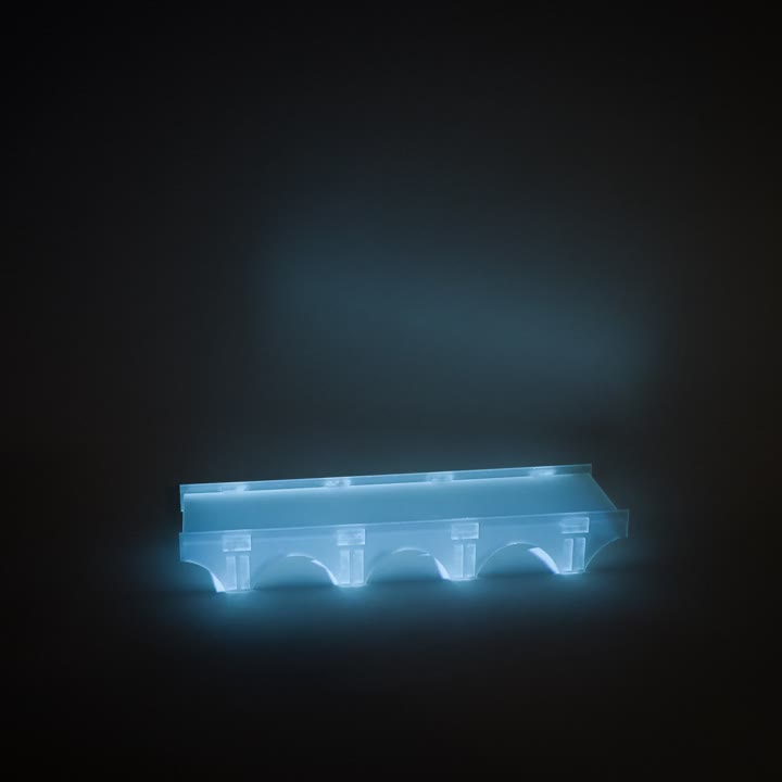 An acrylic bridge illuminated blue against a dark background